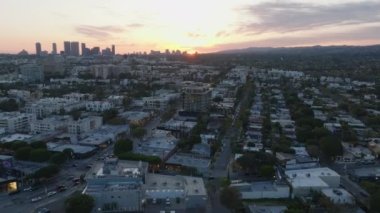 Alacakaranlıktaki şehir manzarası. Renkli günbatımı gökyüzüne karşı yüksek binaların siluetleri. Los Angeles, Kaliforniya, ABD