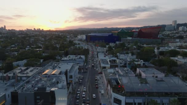 前方の大都市で忙しい通りの上を飛ぶ ロマンチックなカラフルな夕日の空 米国カリフォルニア州ロサンゼルス — ストック動画