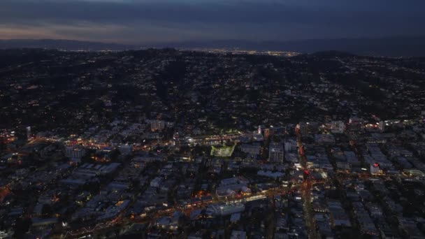 夜間に都市の上の丘の住宅地の空中上昇映像 米国カリフォルニア州ロサンゼルス — ストック動画