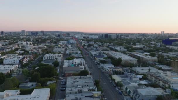 前方の町の開発の上に大都市で日没後に飛ぶ 都市部の高層ビル 米国カリフォルニア州ロサンゼルス — ストック動画