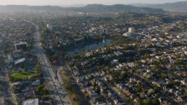 Geniş yerleşim yerlerinin hava indirme görüntüleri. Hollywood Otobanı 'nda yoğun trafik ve altın saatinde evler. Los Angeles, Kaliforniya, ABD.