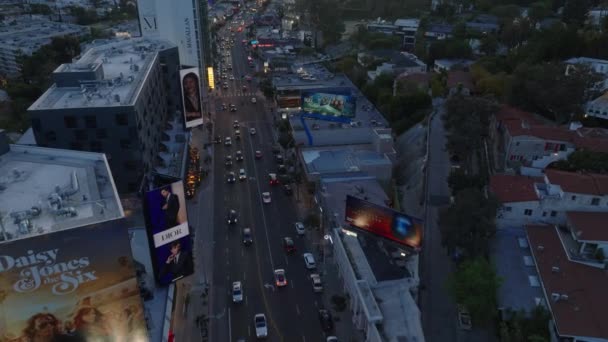 前方ハリウッドの広い楽しい大通りの上に夕暮れ時に飛ぶ ビルの大きなバナーや広告 米国カリフォルニア州ロサンゼルス — ストック動画