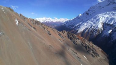 Güneşli yaz günlerinde Himalaya dağları karlı zirvelerle yükseliyor. Tilicho ana kampına giden görkemli Nepal manzarası. Annapurna gezisi.