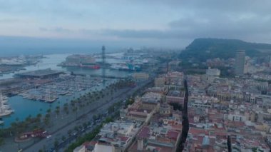 Karanlık çöktüğünde sahil kenti bölgesinin hava panoramik görüntüleri. Rıhtımdaki işlek sokaklar, yat ve yelkenliler marina ve limana yakın. Barselona, İspanya.