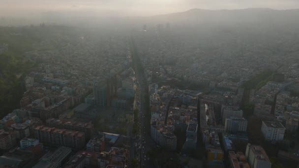 大都市の都市の通りや建物の上を飛ぶ ヘイズや汚染された空気は視認性を低下させる スペインのバルセロナ — ストック動画