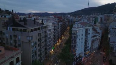 Alacakaranlıkta Metropolis 'teki bir yerleşim bölgesindeki cadde boyunca uzanan çok katlı apartmanlar. Barselona, İspanya.