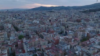 Şehir merkezindeki yoğun şehir gelişiminin üzerine uç. Alacakaranlıktaki büyük şehirde çeşitli çok katlı evler. Barselona, İspanya.