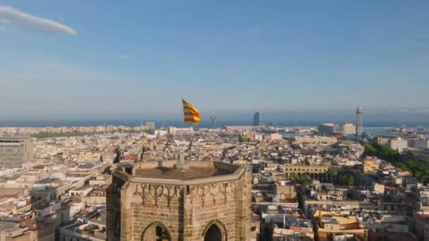 前方在城市上方塔顶的加泰罗尼亚旗上方飘扬 西耶拉在轻风中飞行 西班牙巴塞罗那 — 图库视频影像