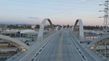 İleriye doğru modern yol köprüsünün üzerinde alacakaranlıkta beton kemerlerle uçar. Los Angeles, Kaliforniya, ABD.