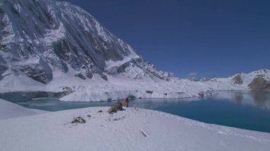 Havadan bakıldığında ilham verici yalnız erkek yürüyüşçü dağlara hayran kalıyor. Nepal 'deki Tilicho Gölü' ne ulaşmak. Seyahat macera yaşam tarzı, Tilicho bakış açısı, Himalayalar.