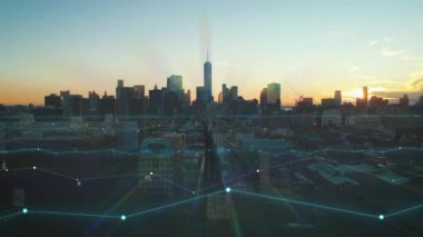 Günbatımının renkli gökyüzüne karşı modern Manhattan gökdelenleriyle gökdelenlerin muhteşem hava manzarası. Dijital çizgiler ve çizelgeler toplanan veri görsel efektlerini analiz ediyor. New York City, ABD.