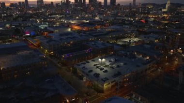 Gece Metropolis 'in havadan görüntüsü. Şehir merkezindeki gökdelenlerin rengarenk günbatımı gökyüzüne doğru eğildiklerini göster. Los Angeles, Kaliforniya, ABD.