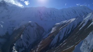 Kuşların gözü Himalaya dağlarını görüyor. Sakin bir havada, karlı tepelerin üzerinde güneş var. Muhteşem nefes kesici Nepal Himalayalar sıradağları. Tilicho ana kampı. Annapurna gezisi.