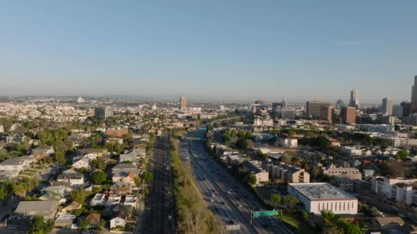 前方の大都市の上に黄金の時間で飛ぶ 住宅街区とによってリード忙しいマルチレーン高速道路の建物 米国カリフォルニア州ロサンゼルス — ストック動画