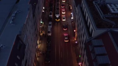 Akşam kentinde yüksek açılı trafik manzarası. Arabalar, tramvay ve bisikletçiler aydınlık yolda ilerliyorlar. Berlin, Almanya.