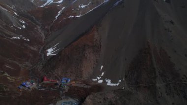 Manang bölgesindeki tepedeki nehir akıntısı ve bina kompleksi ile Tilicho 'nun ana kampını ve izini gösteren hava görüntüleri. Himalayalar. Nepal dağları.