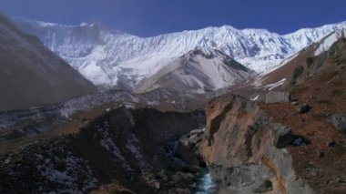 Aerial backwards panorama river valley with snow-capped Himalaya mountain range peaks of Nepal in spring, summer. Tilicho base camp route viewpoints