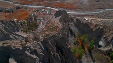 Bhrala köyü ev yerleşiminin üzerindeki tepedeki uçurumlar. Himalayalar dağ sırası kaya oluşumları. Kuzey Nepal Manang bölgesi. Güzel Himalayalar eski köyler