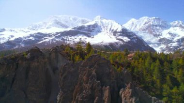 Hava soldan sağa yeşil köknar ağacının tepeleri, karlı Himalayalar 'ın tepeleri, güneşli yaz günlerinde arka planda. Muhteşem nefes kesici Nepal Himalayalar 'ın arka planı 
