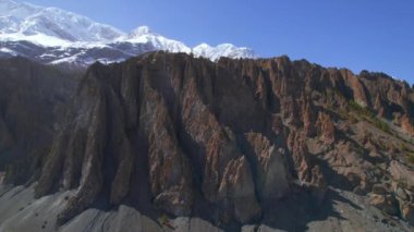 Himalayalar 'ın arkasında beyaz karlı tepeler bulunan hava manzaralı kaya oluşumları. Annapurna gezisi. Nepal 'de. Görkemli Nepal dağlarının arka planı