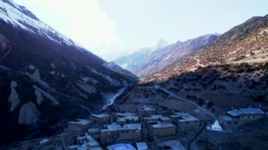 Mamang bölgesindeki Khangshar köyünün renkli geleneksel nepal evlerini geriye doğru gösteren hava görüntüsü. Himalayalar 'da günbatımı geçmişine sahip Tilicho ana kamp yolu.