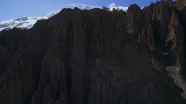 Güneşli mavi gökyüzü gününde Himalaya dağlarının yükselen yükselen manzarası, ardında karlı tepeler bulunan kayalık oluşumlar. Muhteşem nefes kesici Nepal Himalayalar 'ın arka planı