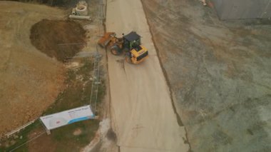 Yükleyicinin yüksek açılı görüntüsü kazılmış materyalleri taşırken ve yığının üzerine atarken. Frankfurt am Main, Almanya.