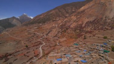 Tepenin yamacındaki Manang köyünün kuş bakışı yerleşim yeri. Annapurna gezisi. Himalayalar 'ın sıradağları. Kuzey Nepal Manang bölgesi. Güzel Himalayalar eski köyler