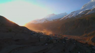 Kuşların gözü Manang köyünün çatılarında uçuyor. Altından bir güneş ışığı vadiyi aydınlatıyor. Manang ev mimarisi. Annapurna dağlık bölge