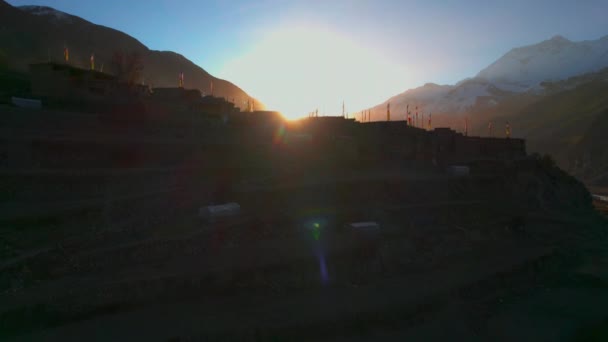 美しい黄金の日の出の背景を持つ空中昇る眺めのマンガ村の家の屋上 ネパールの建築 アナプルナ山脈地域 — ストック動画