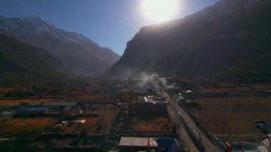 Humde köyündeki evlerin ve arazi mülklerinin üzerinden havadan uçuyorlar. Marshyangdi Vadisi. Himalayalar 'ın sıradağları. Nepal kültürü, yaşam tarzı, topluluk kavramı