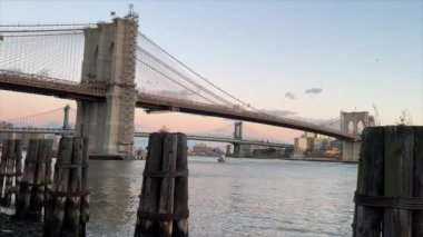 New York, ABD - 2023: NYPD polis sürat teknesi Brooklyn Köprüsü 'nün altında Manhattan şehir merkezinde mavi saatte gün batımından sonra. NYPD teknesi East River 'daki acil durum çağrısına cevap veriyor. Brooklyn Köprüsü