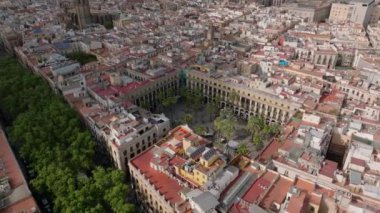 Şehir merkezindeki yoğun şehir gelişiminin hava kaydırağı ve pan görüntüsü. La Rambla Caddesi ve Placa Reial Meydanı 'nın yeşil bitkileri. Barselona, İspanya.