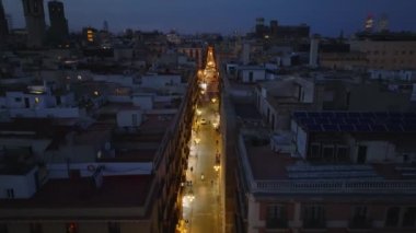 Gece şehrinin hava görüntüsü. Şehir merkezindeki aydınlık sokakta yürüyen insanlar. Barselona, İspanya.