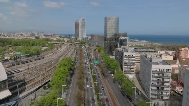 前方忙しい重要な大通りの上を飛ぶ 海沿岸の近代的な都市のボロでマルチレーン道路や鉄道線路 スペインのバルセロナ — ストック動画