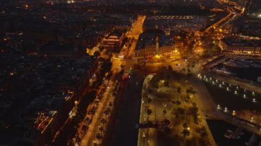 Gece şehrinde taşıma altyapısını kullanan araçların hava görüntüleri. Aydınlanmış sokaklar ve meydanlar. Barselona, İspanya.