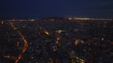 Akşamları tarihi şehir merkezinin hava görüntüleri. Yoğun kentsel gelişim ve aydınlanmış sokaklar. Barselona, İspanya.