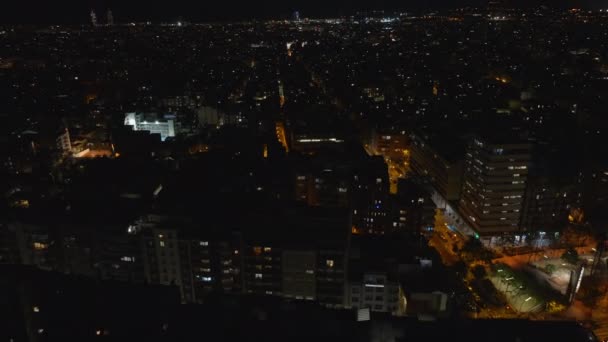 都市部の複数階建ての建物の高角度ビュー 傾きは夜の街並みを明らかにする スペインのバルセロナ — ストック動画