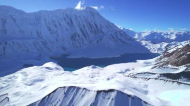 Gökyüzü kuşları Himalaya dağlarının yüksek rakımlı güzel mavi Tilicho gölünün manzarasını görüyorlar. Tilicho ana kamp rotası, Manang, Nepal.