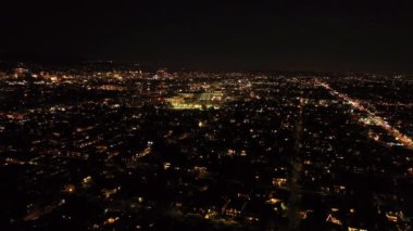 İleri uçaklar gece büyük şehrin üzerinde uçar. Şehirdeki binalar ve sokaklar. Los Angeles, Kaliforniya, ABD