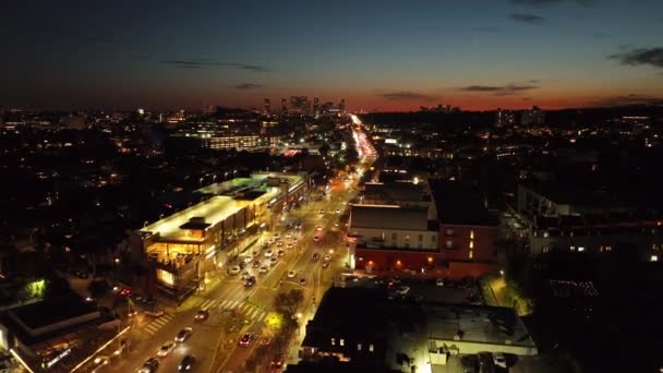 前方の広い通りに重いトラフィックの上を飛ぶ夜に輝く カラフルな夕暮れの空 米国カリフォルニア州ロサンゼルス — ストック動画