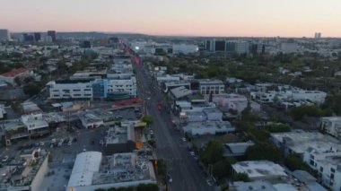 Alacakaranlıkta şehir merkezinde caddelerde giden ve kavşağı geçen araçların hava görüntüsü. Los Angeles, Kaliforniya, ABD