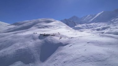 Güneşli bir günde, yüksek irtifada Himalaya dağlarında yürüyüş yapan turist gruplarının üzerinden uçan hava aracı. Tilicho Gölü yürüyüş rotası, Manang, Nepal.