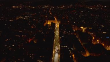 Kentsel çevredeki iyi aydınlatılmış caddenin yüksek açılı manzarası. Gece metropolünde araçlar sürüyordu. Barselona, İspanya.