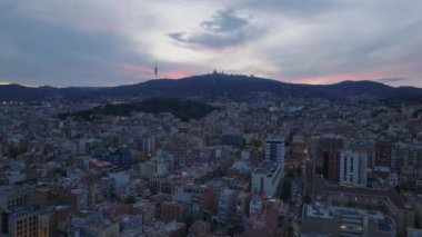 Gün batımında Metropolis 'teki binaların hava panoramik görüntüleri. Tepedeki TV kulesi ve kilise renkli alacakaranlık gökyüzüne karşı. Barselona, İspanya.
