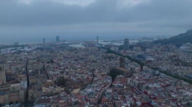 İleriye doğru hava kararınca eski kasabanın üzerinden uçacağız. Şehrin havadan panoramik görüntüsü ve arka planda liman. Barselona, İspanya.