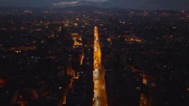 Akşam kentinde, uzun ve aydınlık caddenin üzerinde ileriye doğru uçar. Metropolis 'in havadan görünüşü. Barselona, İspanya.