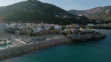 Deniz kıyısındaki konutların ve restoranların inanılmaz sinematik görüntüleri. Altın saatinde şehirdeki binaların havadan görüntüsü. Garraf, İspanya.