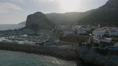 Deniz kıyısındaki liman ve binaların havadan çekilmiş görüntüleri. Arka planda dağlar. Garraf, İspanya.
