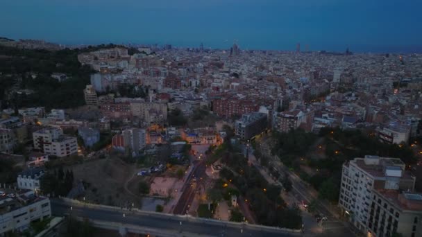 前方の都市の上の夕暮れ時に飛ぶ アパートの建物に囲まれた通りや交差点 スペインのバルセロナ — ストック動画